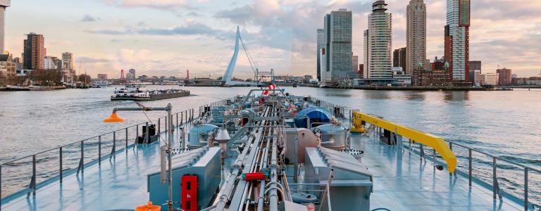 Gas tanks on the river Nieuwe Maas approaching Rotterdam, Netherlands at sunset.