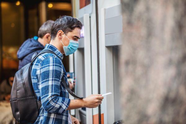 Man wearing an n95 mask using an ATM