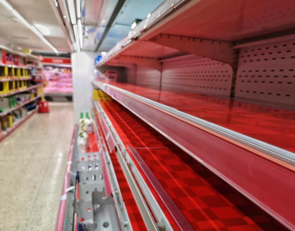 A row of empty shelves in a supermarket during COVID-19