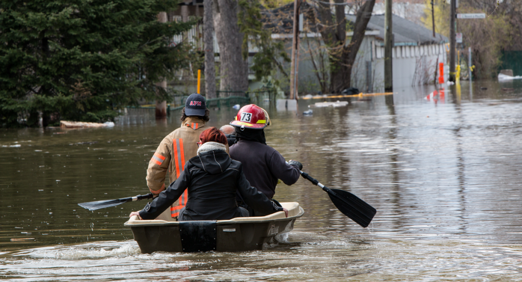 Navigating a flooded street in Montreal by boat